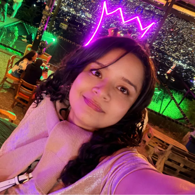 Nathaly Rodriguez taking a selfie at a hillside viewpoint at night